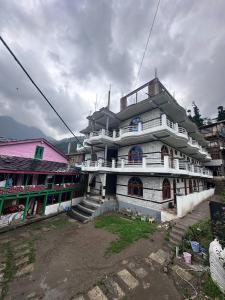 a large white building in the middle of a town at Boom Shankar in Kalgha