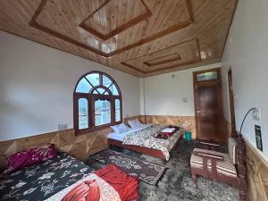 a bedroom with two beds and a ceiling with windows at Boom Shankar in Kalgha +12 photos