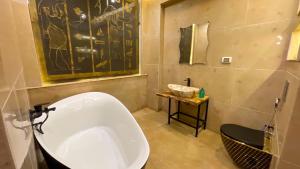 a bathroom with a large white tub in a room at RAFiF Pyramids View Hotel in Cairo +41 photos