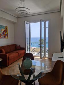 a living room with a glass table and a view of the ocean at Azur Pearl - Luxury Sea View Apartement - La plage à vos pieds in Nice