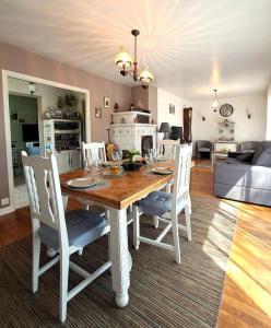 a dining table and chairs in a living room at La maison vautier in Vendeuvre-sur-Barse