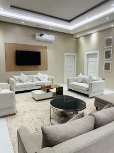 ein großes Wohnzimmer mit Sofas und einem Fernseher in der Unterkunft Zahrtishrin in Sur