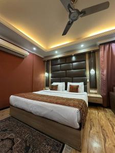 a bedroom with a large bed and a ceiling fan at HOTEL ROYAL MILAD in Srinagar