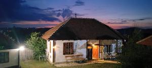 a small white house with a roof at night at Konak ispod Subjela in Ševrljuge