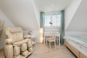 a bedroom with a bed and a chair and a desk at Ferienhäuser TraumZeit in Zingst