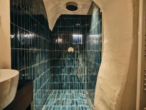 a bathroom with a shower with blue tiles at Stuveles Apartments in Brixen