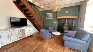 a living room with a blue couch and a tv at Le charron in Saint-Mathieu