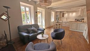 a living room with a couch and chairs and a table at Le charron in Saint-Mathieu