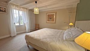 a bedroom with a white bed and a window at Le charron in Saint-Mathieu