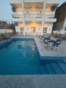 a swimming pool in front of a house at Happiness Guest House in Luxor