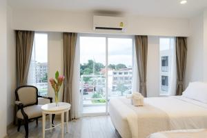 a hotel room with two beds and a window at Arsh Boutique Hotel in Chiang Mai
