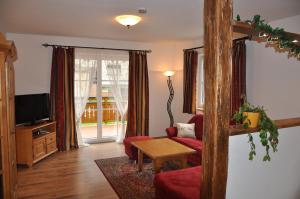 een woonkamer met een rode bank en een tv bij Appartementhaus Eberlhof in Pruggern