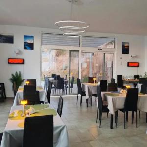 a dining room with tables and chairs and a large window at Kandania Paradise in Kántanos