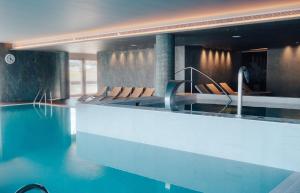 a swimming pool with chairs in a building at Meliá Ria Hotel & Spa in Aveiro