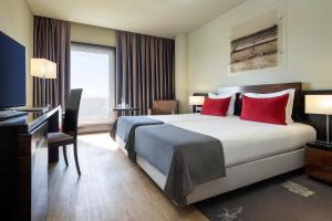 a hotel room with a large bed and a desk at Meliá Ria Hotel & Spa in Aveiro