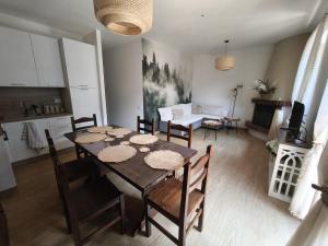 a dining room and living room with a table and chairs at Apartament BARBARA in Branzi