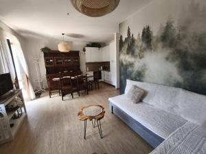 a living room with a couch and a dining room at Apartament BARBARA in Branzi