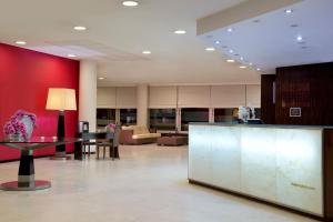a lobby with a red wall and a reception desk at Meliá Ria Hotel & Spa in Aveiro