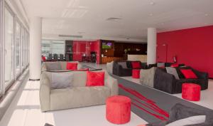 a living room with couches and red walls at Meliá Ria Hotel & Spa in Aveiro +26 photos