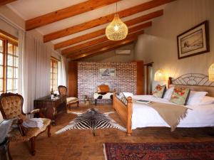a bedroom with a bed and a brick wall at Swartklip Game Lodge in Riversdale +111 photos