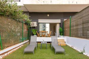 a patio with chairs and a table on the grass at TT holidays Prestigia Hay Riad-Pool in Rabat