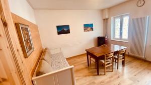 a dining room with a table and a wooden floor at villa Ada apartment in Cercivento