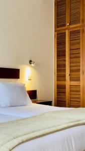 a bedroom with a bed and a wooden cabinet at Vila Ventura Village in Caniço