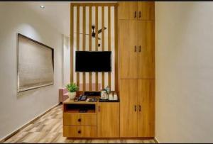 a room with a desk with a tv and a cabinet at Hotel the Infinity in Rajkot