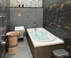 a bathroom with a bath tub and a toilet at Hotel the Infinity in Rajkot