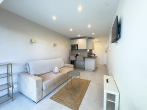 a living room with a couch and a table at Sublime apartment - Beachfront in Saint-Laurent-du-Var