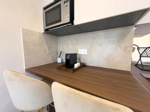 a kitchen with a counter with a microwave and chairs at Sublime apartment - Beachfront in Saint-Laurent-du-Var +3 photos