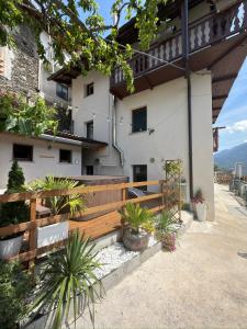 a building with a wooden fence and some plants at Casa Jeny in Fenis