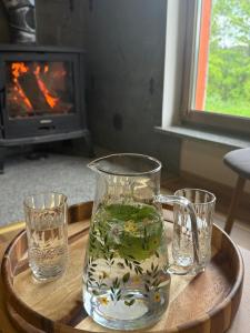 a glass pitcher of water on a tray with two glasses at Agroturystyka Monte Luna - domki in Czarnów