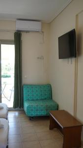 ein Wohnzimmer mit Sofa und Flachbildfernseher in der Unterkunft Asfodelos Apartment Hotel in Kakovatos