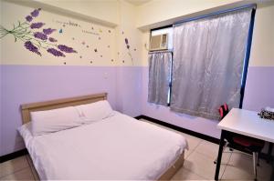 a small bedroom with a bed and a window at Love Fengchia in Taichung