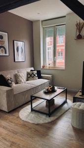 a living room with a couch and a coffee table at L'instant Cosy in Gamaches