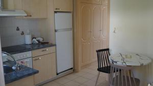 eine Küche mit einem weißen Kühlschrank und einem Tisch in der Unterkunft Asfodelos Apartment Hotel in Kakovatos
