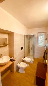 a bathroom with two sinks and a toilet and a shower at villa Ada apartment in Cercivento +33 photos