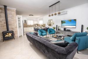 a living room with a couch and a fireplace at Villa Glory in Even Menahem