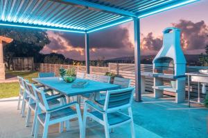 a blue table and chairs on a patio with a grill at Villa Glory in Even Menahem