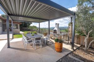 a pergola with a table and chairs on a patio at Villa Glory in Even Menahem