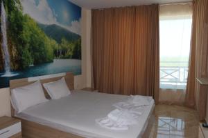 a bedroom with a bed with two towels on it at goldenseaview in Pomorie +67 photos