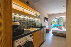 a kitchen with a sink and a washing machine at Palmea Suites in Pefki