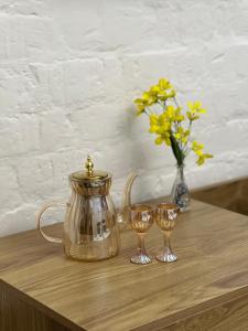 a tea pot and two wine glasses on a wooden table at AERON hotel in Yakkasaray