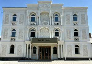 a white building with aania hotel sign in front at AERON hotel in Yakkasaray