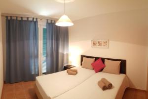 a bedroom with a large white bed with a window at Rivera 3 in Porto Santo
