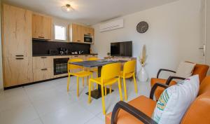 a kitchen and living room with yellow chairs and a table at Numéro 1 in Morvilliers