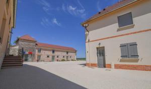 an empty street with two buildings and a blue sky at Numéro 1 in Morvilliers