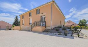 a yellow house with a statue in front of it at Numéro 2 in Morvilliers