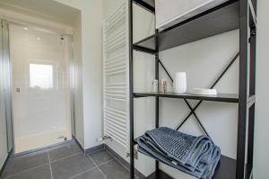 a room with a closet with shelves and a shower at Numéro 2 in Morvilliers +14 photos